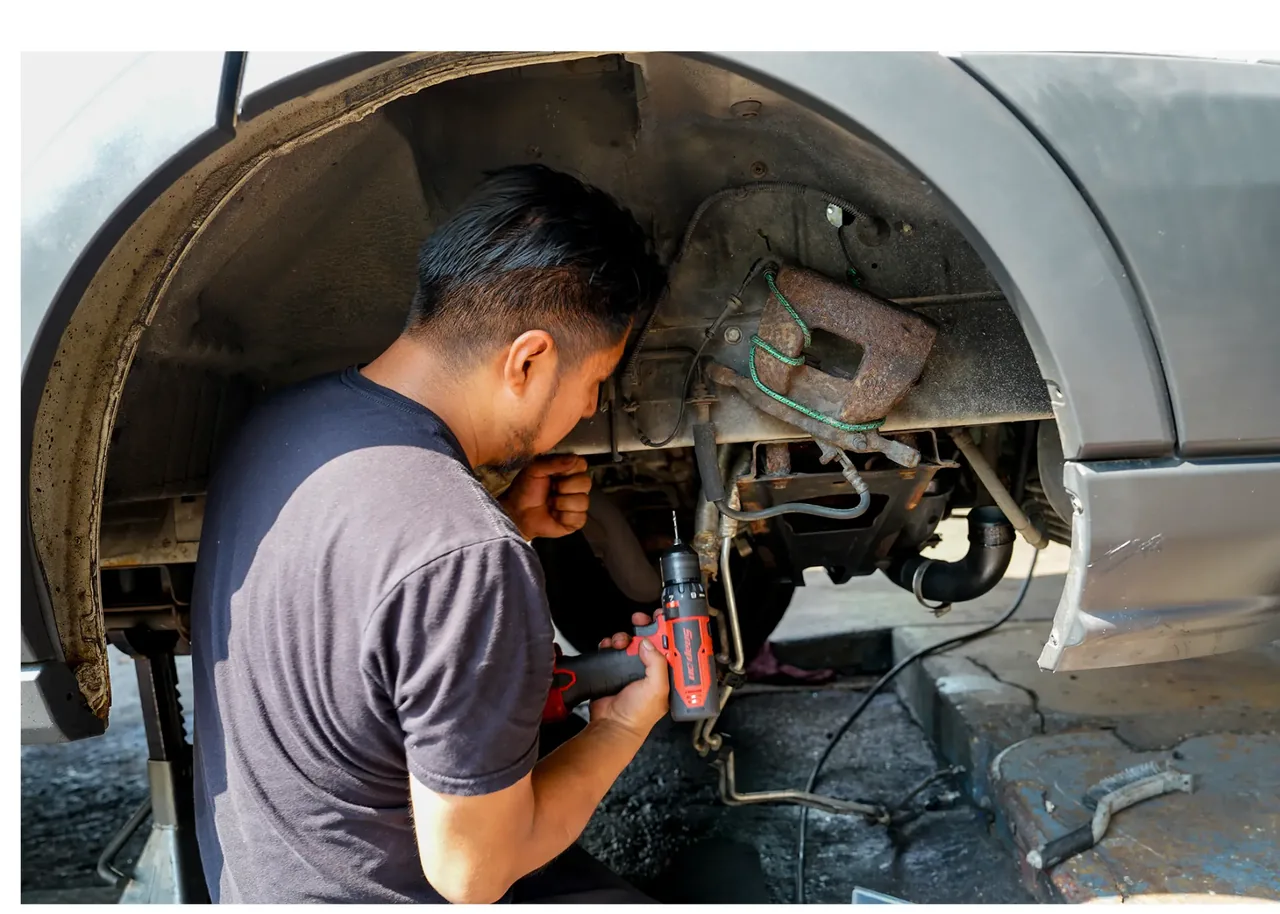 Queens Auto Repair mechanic servicing suspension and brake components