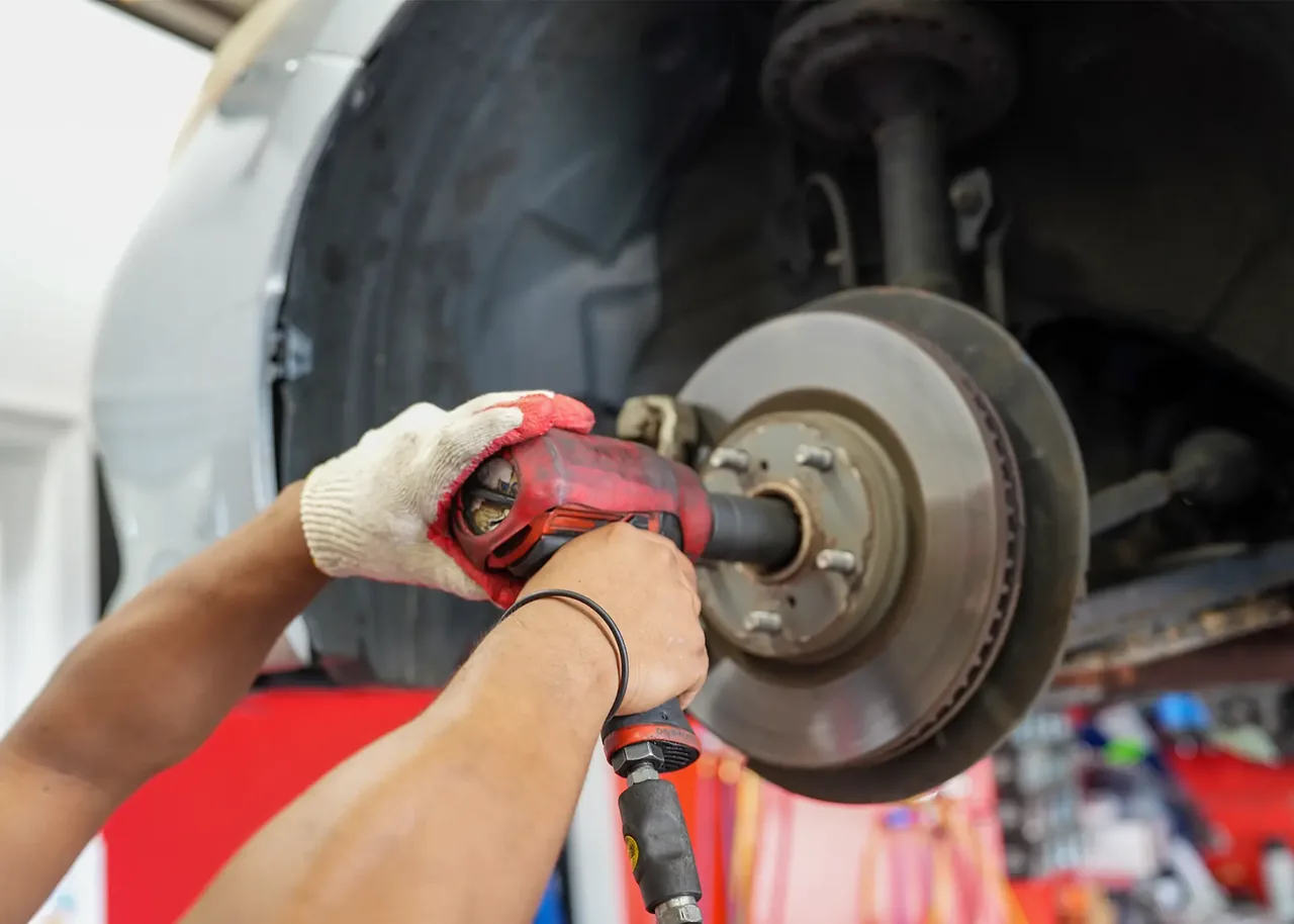 Queens Auto Repair mechanic working on a vehicle brake rotor